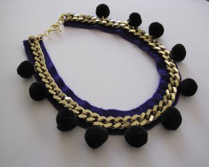 1 gold chain necklace on a deep purple band with black poms poms